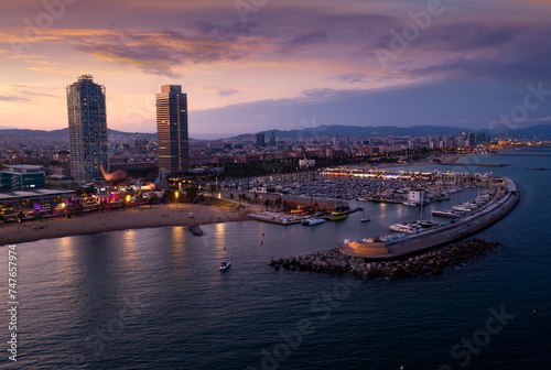 Aerial view of seaside area of Barcelona overlooking two modern skyscrapers on Mediterranean coast and marina for pleasure yachts in summer dusk  Spain