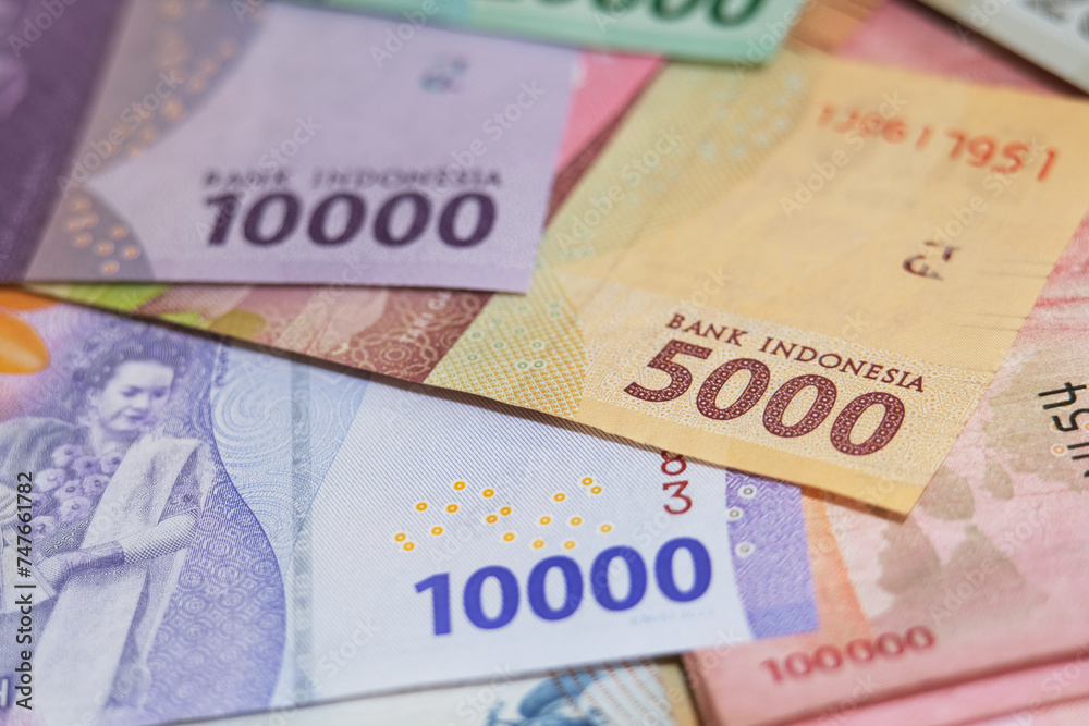 Close up of Rupiah banknotes. The rupiah is the official currency of Indonesia issued and controlled by Bank Indonesia Close up of Rupiah banknotes. The rupiah is the official currency of Indonesia issued and controlled by Bank Indonesia