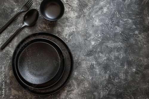 Elegant black tableware set on dark textured background for fine dining