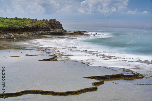 The unique coastline of Inarajan Pools Beach Park, Guam with a long exposure of the coastal waves photo