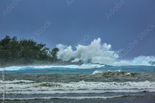 High surf and rough seas hit Anae Island on Guam during typhoon season on a cloudless day