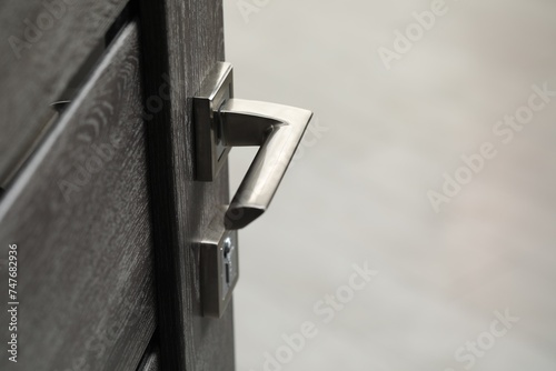 Open wooden door with metal handle, closeup photo