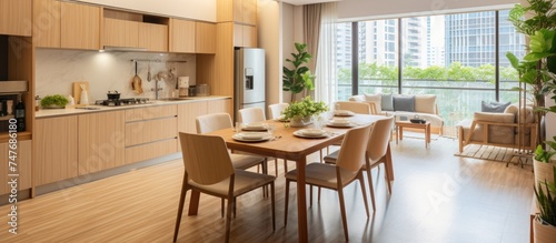 This image shows a spacious dining room and living room in a large apartment. The dining area features a table and chairs on a hardwood floor.
