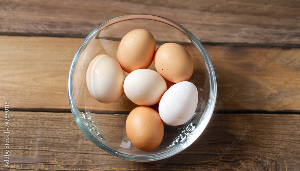 Eggs in the bowl of glass on a wooden background Eggs in the bowl of glass on a wooden background