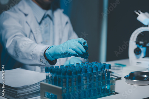 Many test tubes were analyzed by experts, A researcher is carefully studying the liquid contained in a test tube because it is an important area of research.