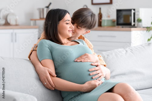 Young pregnant couple huggi...