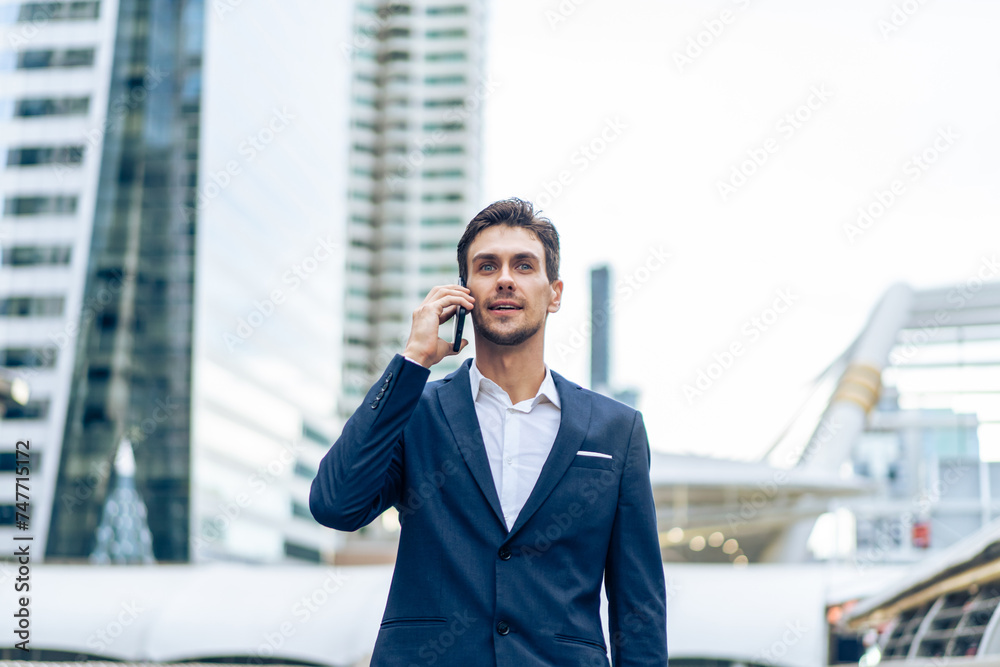 Caucasian young businessman talk on smartphone while walk in the city. Caucasian young businessman talk on smartphone while walk in the city.