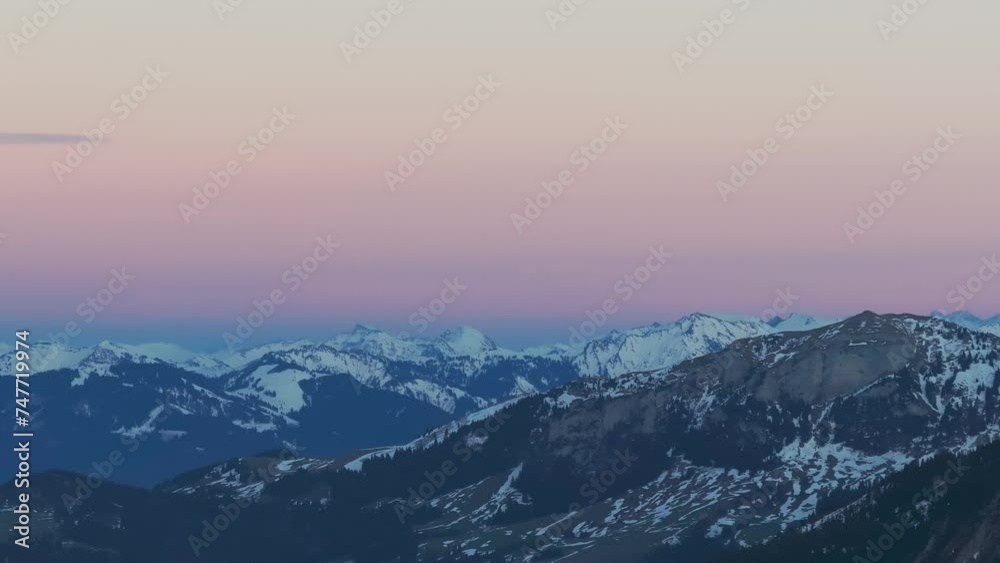 Marvel at the picturesque silhouette of a snow-covered mountain range during sunrise, captured from a drone perspective. Marvel at the picturesque silhouette of a snow-covered mountain range during sunrise, captured from a drone perspective.