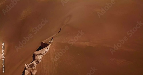Golden sand dune in the middle of hot dry desert in middle east steep smooth rock clay cliff mountain surrounded by moving particle in Iran geopark nature natural adventure scenic wonderful landscape photo