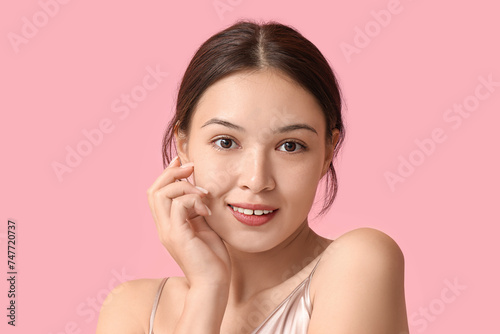 Beautiful young Asian woman on pink background