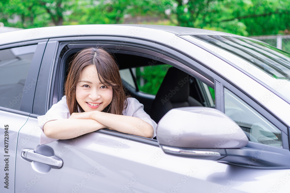 運転席から顔を出す若い女性