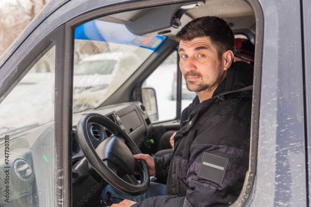 young handsome man driving in the cab of a large truck young handsome man driving in the cab of a large truck
