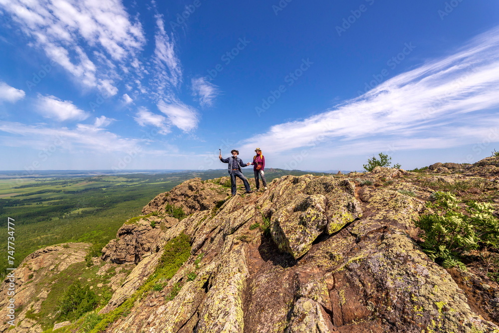 happy mature married couple traveling through the Ural mountains on a summer day