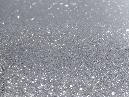 Blurred bokeh light on gray silver background. New Year holidays template. Abstract glitter defocused blinking stars and sparks.