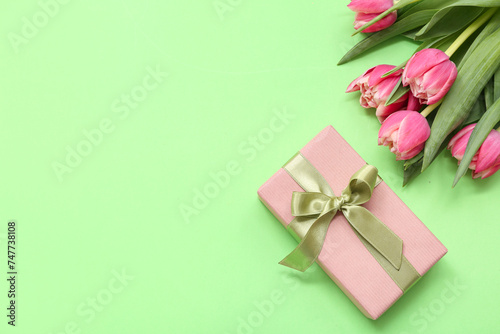 Gift box and bouquet of beautiful tulips on green background. International Women's Day © Pixel-Shot