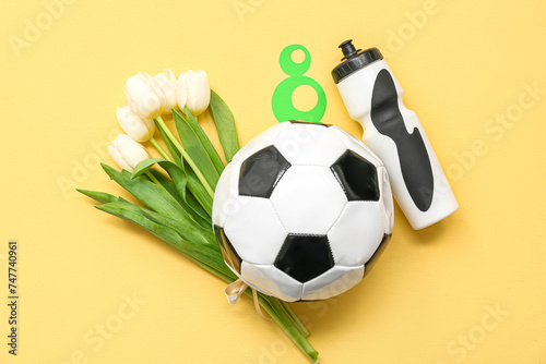 Composition with soccer ball, bottle of water and tulip flowers on color background. International Women's Day