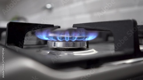 Primer plano de hornalla de estufa a gas natural con llama azul  photo