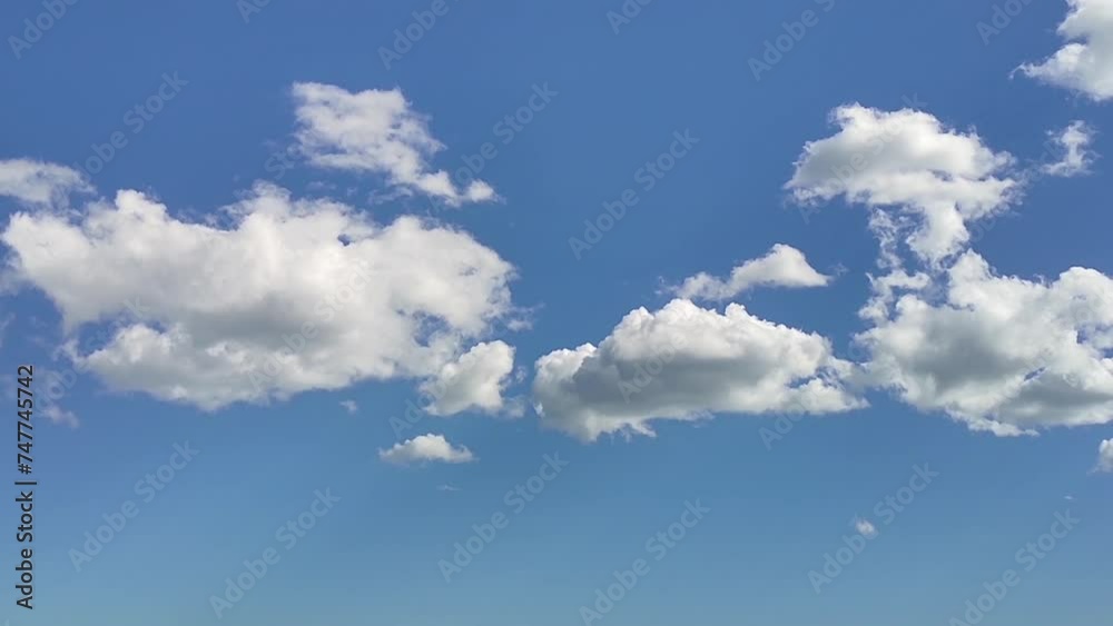 Fluffy white clouds on a bright blue sky. Summer happy day background. Fluffy white clouds on a bright blue sky. Summer happy day background.