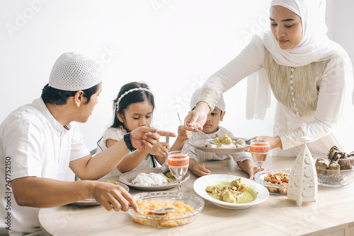 Muslim family enjoying special food at dining room during Eid Mubarak moment.