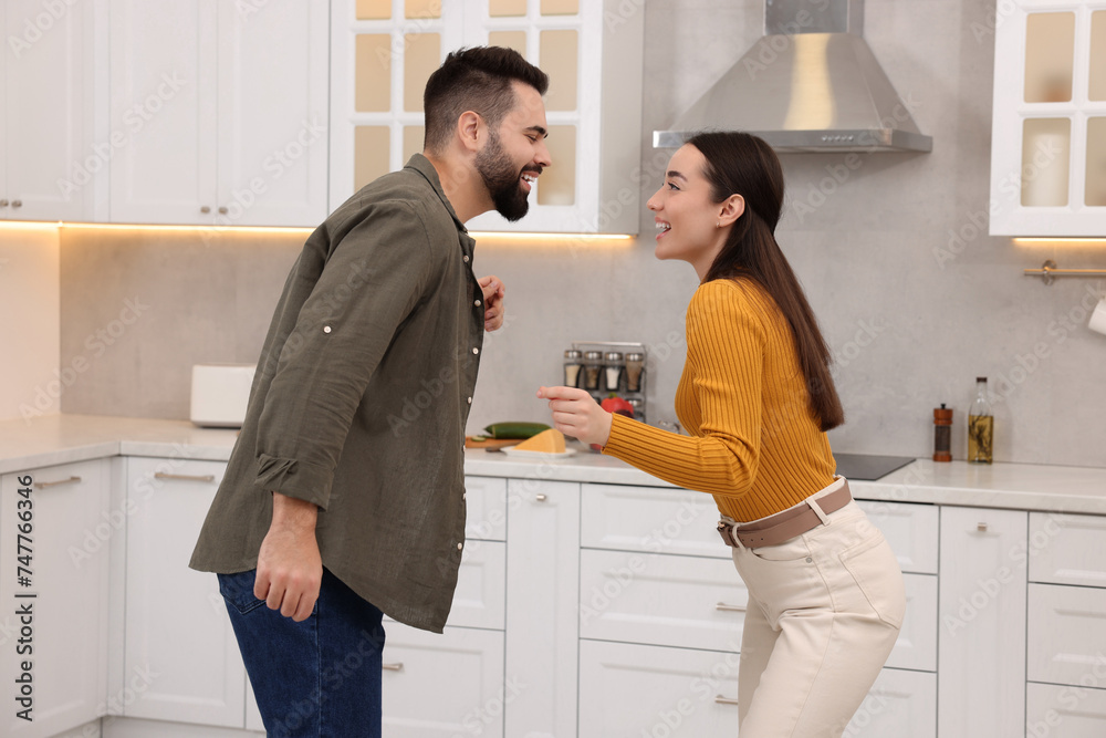 Happy lovely couple dancing together in kitchen Happy lovely couple dancing together in kitchen