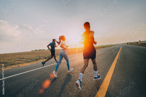 Three runners is running on the road at outdoors , healthy lifestyle and sport concepts.   © sutadimages