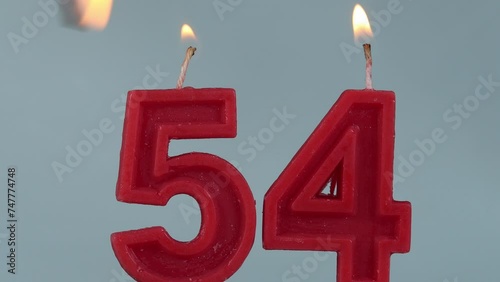 close up on a red number fifty fourth birthday candle on a white background.
 photo