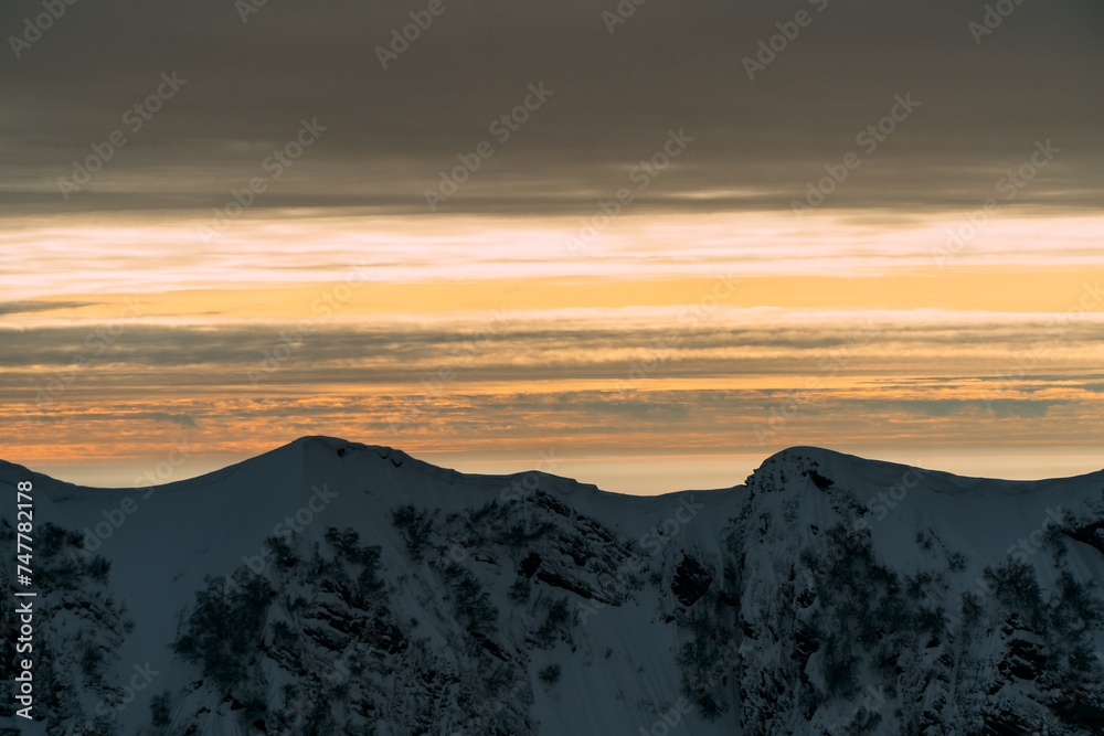 View of the winter sunset and snow-covered mountains View of the winter sunset and snow-covered mountains