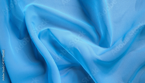 Blue abstract background, the fabric lies in soft waves. chiffon, translucent material. view from above