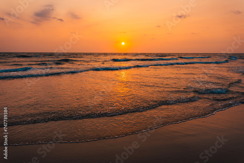 Sunset on the beach and orange sea waves © artrachen