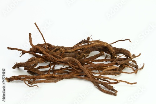 Organic dried roots of dandelion, Taraxacum officinale, traditional herbal medicine. Roots prepared for making tinctures and medicine on the white background.