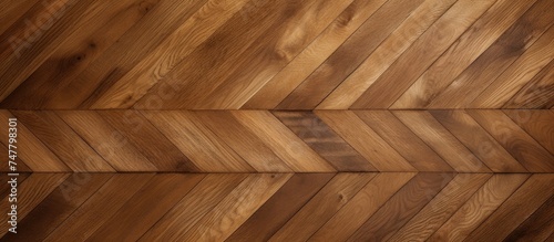 A detailed view of a seamless wooden floor featuring a geometric chevron pattern. The hardwood floor showcases intricate craftsmanship, creating a visually appealing and unique design. © Vusal