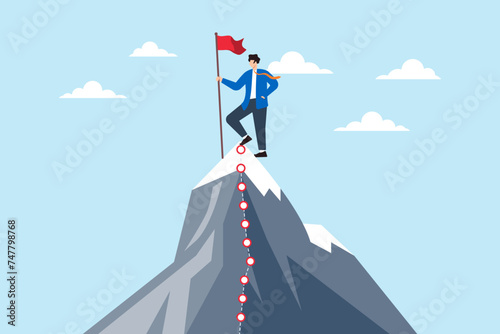 Businessman stands on mountain peaks, holding a red flag marking milestones path. Concept of journey to success, overcoming challenges, and achieving goals in business