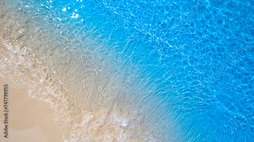 Top view of sandy beach for summer vacation concept. Nature of the beach and sea in summer with sunlight, and light sand. The sea sparkles against the blue sky. Sandy Beach for summer vacationconcept 