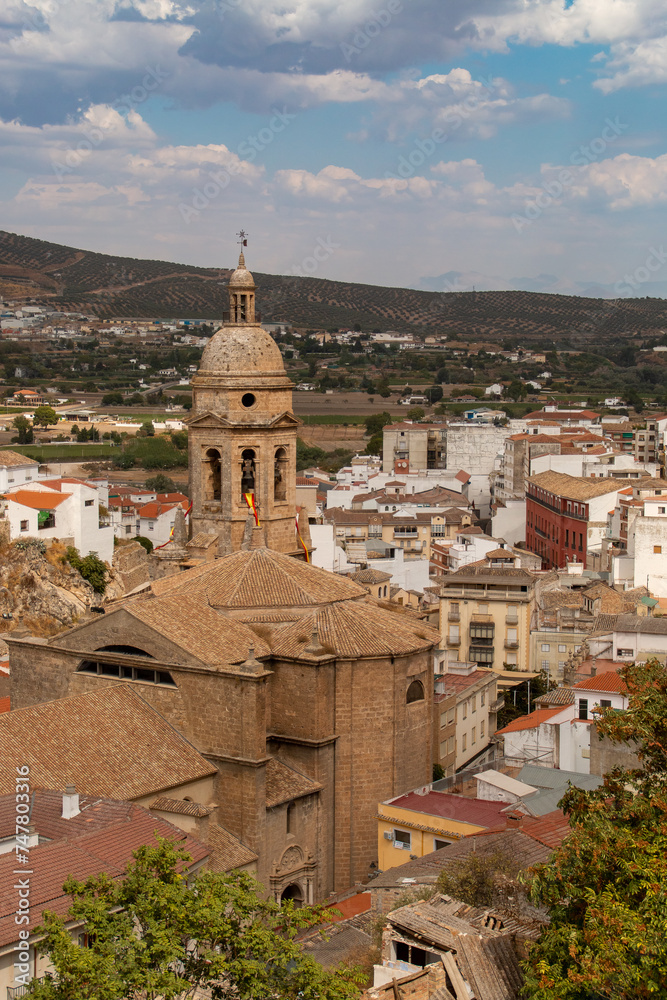 Vista de la La iglesia mayor de Santa María de la Encarnación desde el mirador Isabel I de Castilla en Loja. Vista del campanario y tejado rodeado de los edificios residenciales en Loja, España.