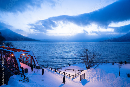 夕暮れ時の支笏湖にかかる橋と雪 photo