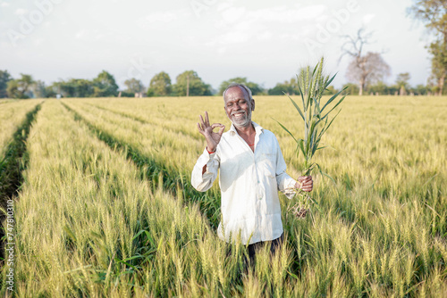 Indian farmer standing at wheat field, Happy farmer photo