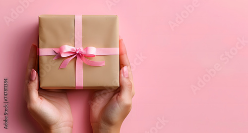 hand holding giftbox or wrapped gift with satin bow ribbon © Your isolated stock