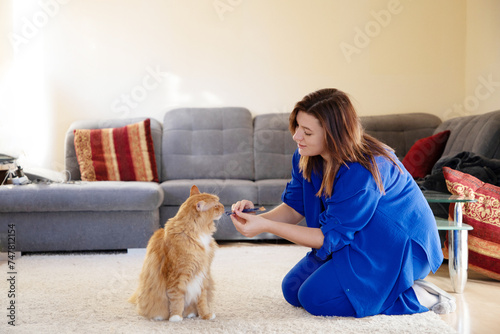 young plus size girl playing with cat in room © Cavan