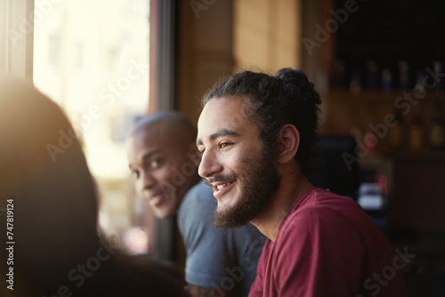 Face, smile and man with friends in coffee shop together for conversation or bonding on weekend. Customer, relax and summer with group of happy young friends in cafe or restaurant for time off photo