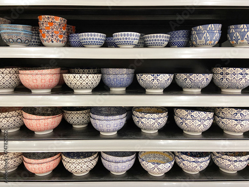 colorful ceramic bowls and glasses on display shelves in supermarkets