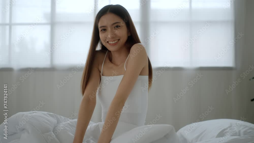 Refreshing moment of asian woman wake up and stretching in bed at sunrise. Happy female waking up and ready to start new day in the morning. Have a good day. Refreshing moment of asian woman wake up and stretching in bed at sunrise. Happy female waking up and ready to start new day in the morning. Have a good day.