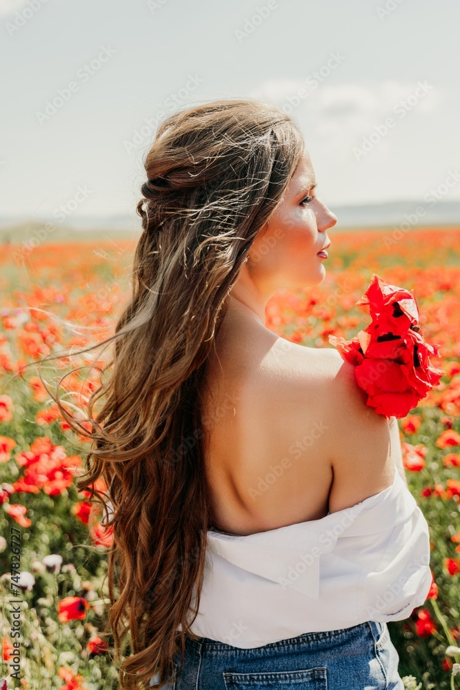 Naklejka premium Woman poppies field. Side view of a happy woman with long hair in a poppy field and enjoying the beauty of nature in a warm summer day.
