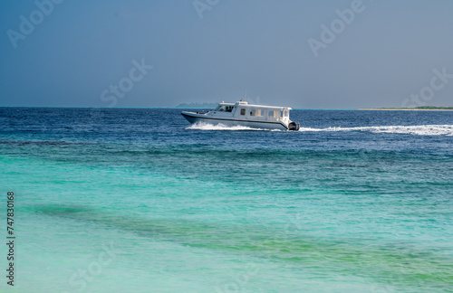 White boat floats fast on the surface of the sea. © Denis