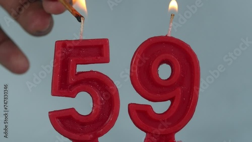 close up on a red number fifty ninth birthday candle on a white background.
 photo