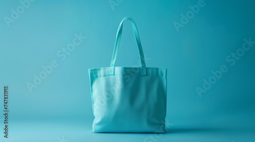 Blue tote bag on a blue background. The bag is made of canvas and has a gusseted bottom.