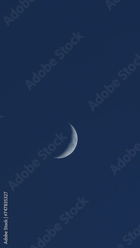 This vertical video captures the serene moment of two silhouetted hands in a clapping gesture against a tranquil night sky. The space between the applauding hands frames a delicate crescent moon