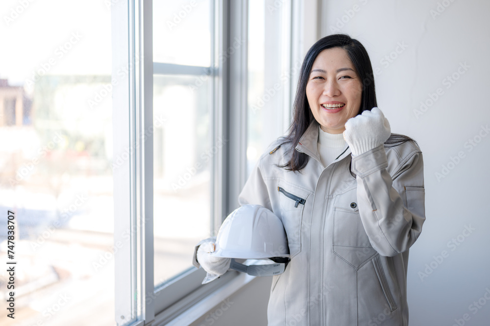 笑顔とガッツポーズの作業着女性 笑顔とガッツポーズの作業着女性