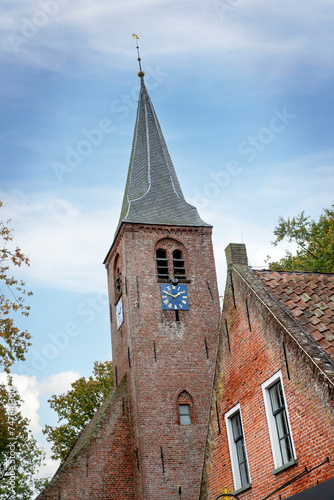 Church tower and historical house facade at Roden Drenthe Netherlands. Catharina church.  photo