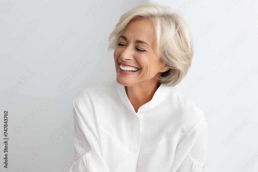 Fototapeta premium Joyful mature woman laughing in casual attire. Happiness and positivity.