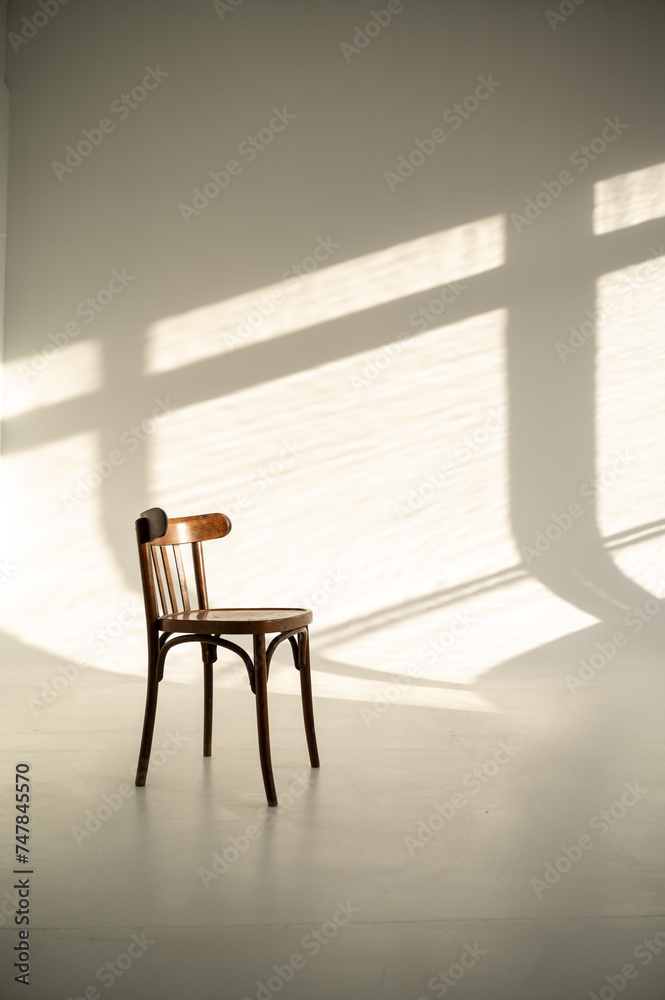 Fototapeta premium Old wooden chair in the interior of a photo studio with sunlight